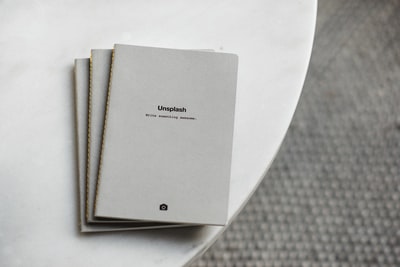 三本白色软装订的书放在白色的表面上